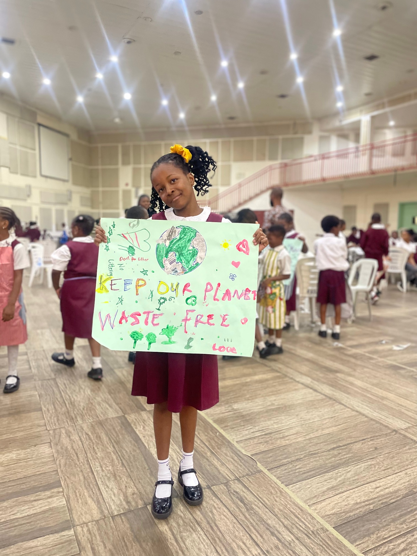 A child holding a hand-drawn climate poster